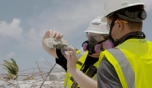 In this July 1, 2021, photo NIST staff members examine pieces of concrete removed from the debris pile at the site of the Champlain Towers South building partial collapse.